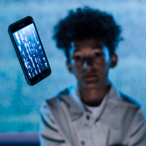 woman of color looking at a phone flying through the air